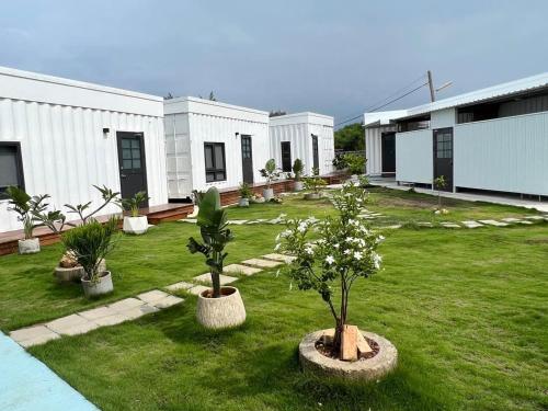 a building with two trees in a yard at Second Hostel in Xiaoliuqiu