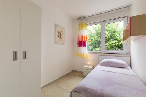 1 dormitorio con cama y ventana en Apartment Miaa, en Split