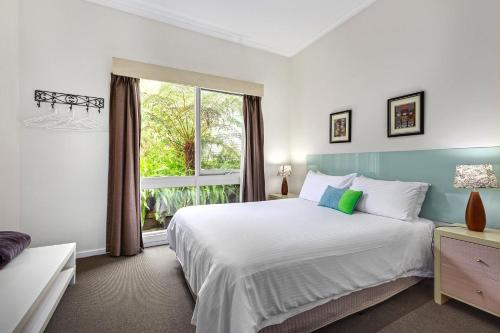 um quarto com uma cama grande e uma janela em Valley Farm Vineyard Villas em Healesville