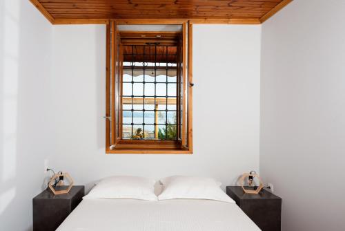 1 dormitorio con cama y ventana en The Sea Front Fisherman’s house, en Kato Gatzea