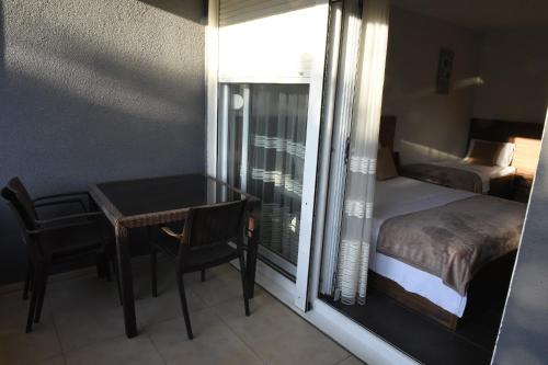 a bedroom with a table and a bed and a window at Apartmani Sutomore Tri Palme in Sutomore