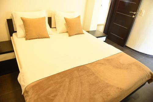 a large bed with white sheets and pillows in a room at Apartmani Sutomore Tri Palme in Sutomore