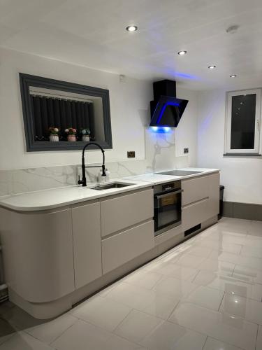 a white kitchen with a sink and a stove at Luxury 2 Bedroom Apartment in S10 1GD in Walkly