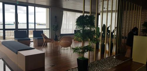 a lobby with chairs and potted plants in a building at One Residence #11AI in Batam Center