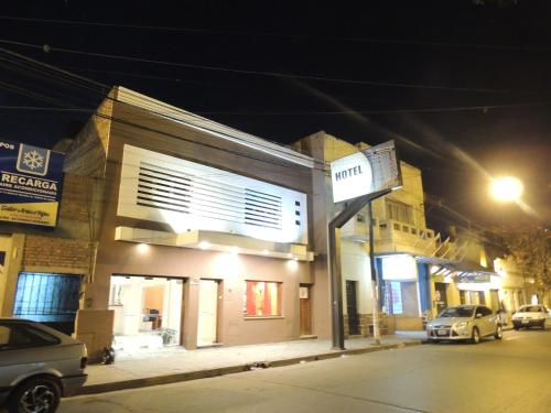 a building on a street at night with cars parked outside at Hotel Buenos Aires in Salta