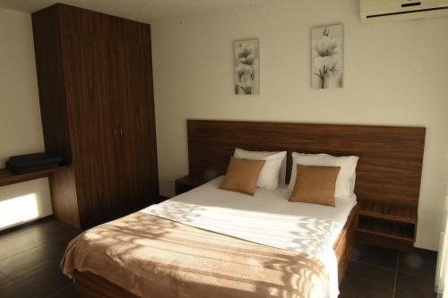 a bedroom with a large bed with two pillows at Apartmani Sutomore Tri Palme in Sutomore