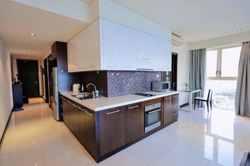 a kitchen with white cabinets and a counter top at The Sea Luxury Nha Trang Apartment in Nha Trang