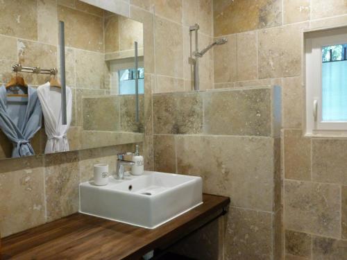 une salle de bain avec un lavabo et un miroir dans l'établissement Le Cypressat, à Les Plans