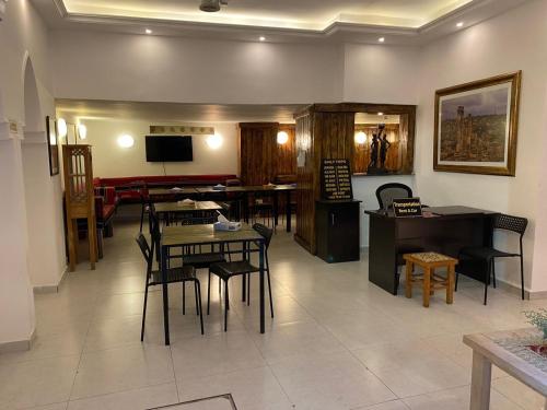 a living room with tables and chairs and a television at Art Hotel Downtown in Amman