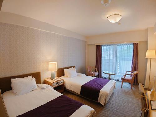 神戸市にあるメルヴェール有馬のベッド2台と窓が備わるホテルルームです。