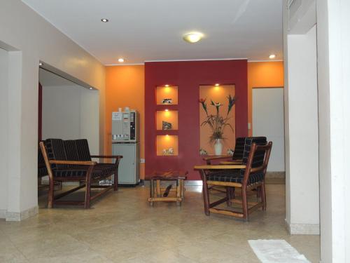 a living room with chairs and a table and a refrigerator at Hotel Buenos Aires in Salta