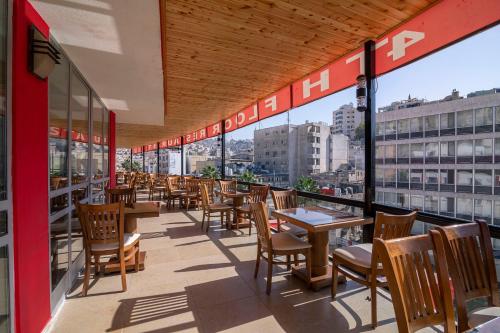 un restaurante con mesas y sillas en un balcón en Art Hotel Downtown, en Amán