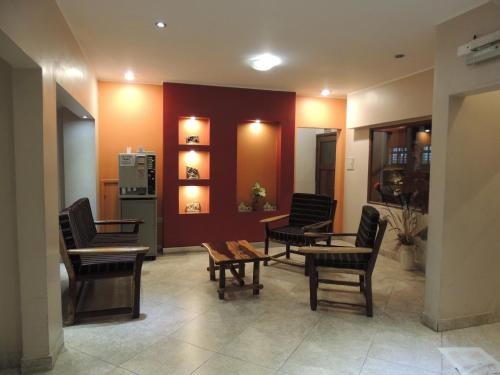 a waiting room with chairs and tables and a refrigerator at Hotel Buenos Aires in Salta