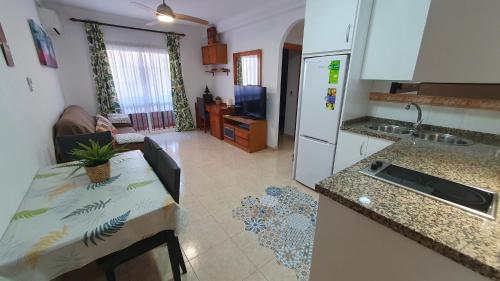 a kitchen and a living room with a table and a refrigerator at Rico Apartaments Ricosol in Torrox Costa