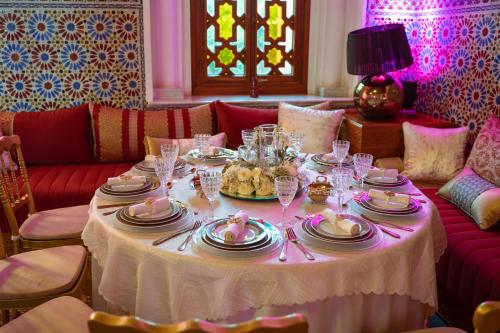 uma mesa com pratos e copos de vinho em Nomadz Palace em Marraquexe