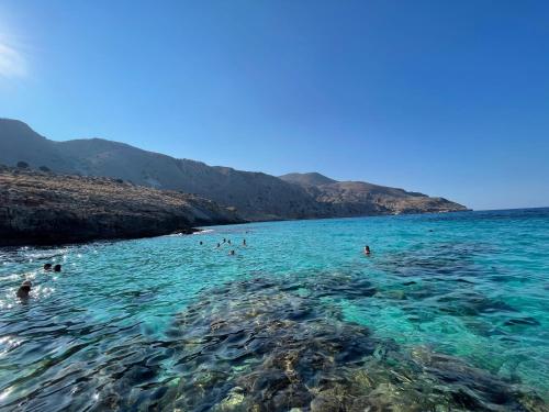 a group of people swimming in the water at Arbutus - Relaxing apartment with Fantastic Views in Georgioupolis