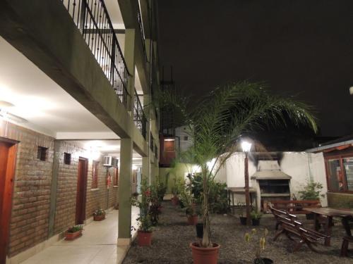 a courtyard of a building with palm trees and a table at Hotel Buenos Aires in Salta