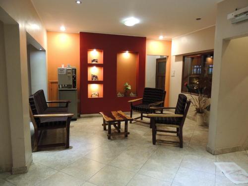 a living room with chairs and a table and a kitchen at Hotel Buenos Aires in Salta