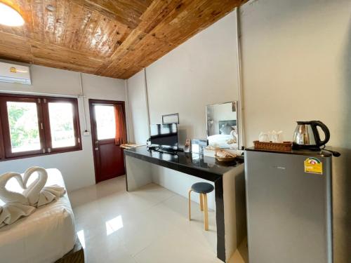 a room with a desk with a bed and a mirror at MOOK BOONCHU HOTEL in Koh Mook