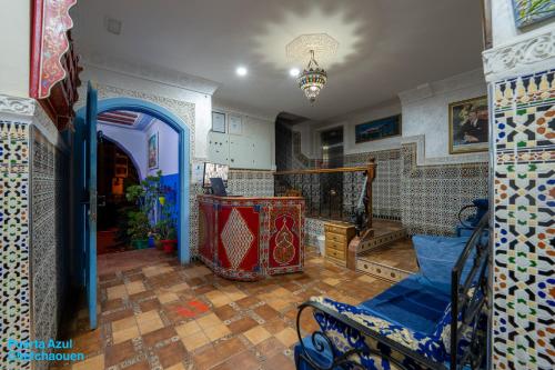 a living room with a blue chair and a staircase at Puerta Azul in Chefchaouene