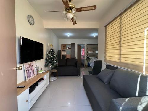 a living room with a couch and a tv at 3 Bedroom Apartment by Romz in Camaman