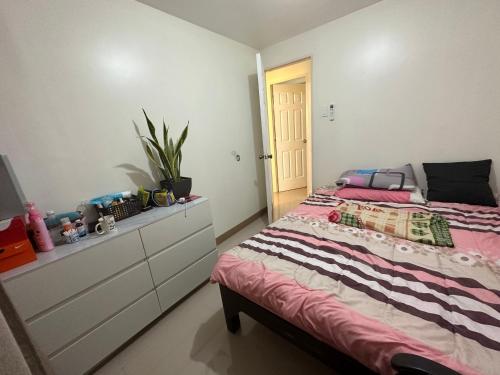 a bedroom with a bed and a dresser at 3 Bedroom Apartment by Romz in Camaman