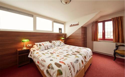 um quarto com uma cama grande e janelas em Herberg St. Brigida em Noorbeek