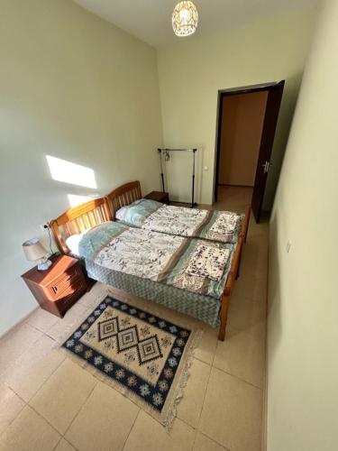 a bedroom with two beds and a table and a door at Apartment near Tskaltubo spa restort in Tskaltubo
