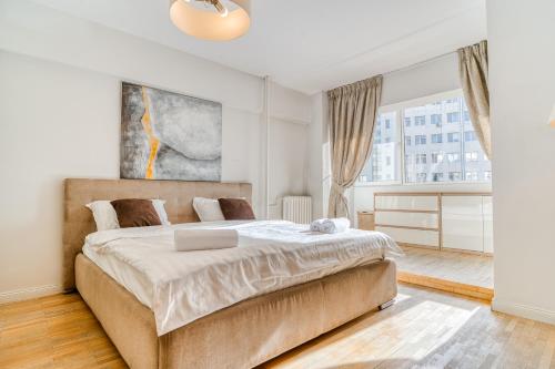 a bedroom with a large bed and a large window at Victoriei Elite Apartments-Free Minibar in Bucharest