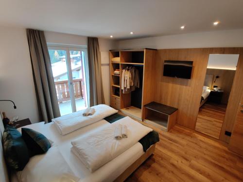 a large bedroom with two beds and a television at Apartment Villa Stefania in Selva di Val Gardena