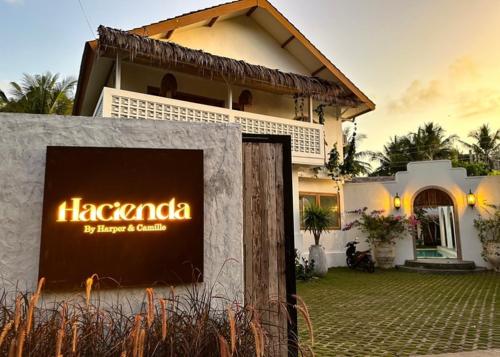 a house with a sign in front of it at Hacienda Villa Watukarung in Watukarung