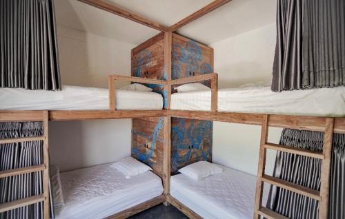 a room with three bunk beds in a room at Hacienda Villa Watukarung in Watukarung