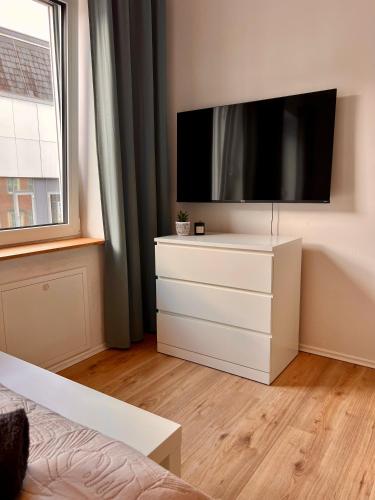 a white dresser with a flat screen tv in a bedroom at Monteurswohnungen in Dorsten - Zentrum - NEU saniert in Dorsten