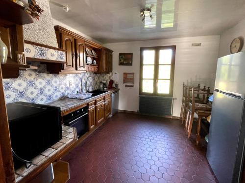 a kitchen with a refrigerator and a table in it at Gîte du canal rue de la Tuilerie in Amilly