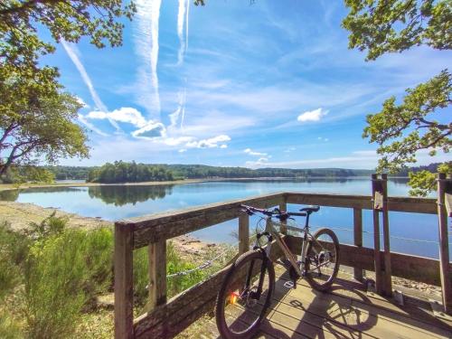 a bike parked on a fence next to a lake at LA VIGNE in Saulieu