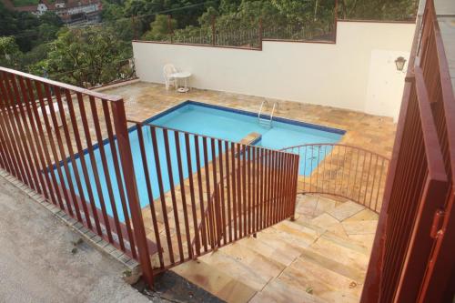 einen Blick über einen Pool hinter einem Zaun in der Unterkunft apartamento águas de lindoia itaigara in Águas de Lindóia