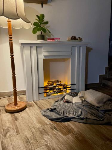 a living room with a fireplace with a blanket and a lamp at La Turcu in Văliug