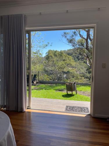 a room with a sliding glass door with a bench outside at River Retreat Studio in Grays Point