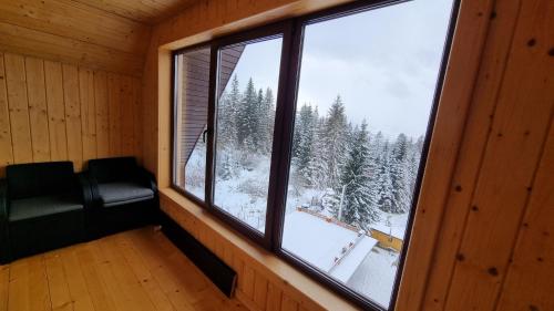 a room with a window with a view of a snowy forest at SPA Resort Villa Sofia in Yablunytsya