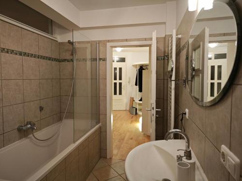 a bathroom with a sink and a tub and a mirror at Exceptional short-term rental in Düsseldorf