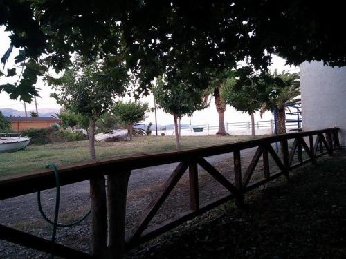 a wooden fence with a hose on it next to trees at Holiday Tolofona Beach in Eratini