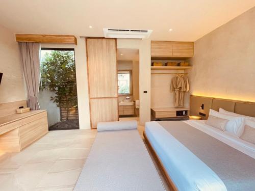 a bedroom with a large bed and a bathroom at Eden Resort & Villas in Patong Beach