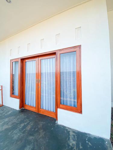 a white building with wooden doors and windows at Turtle House Surf & Stay in Airsatang