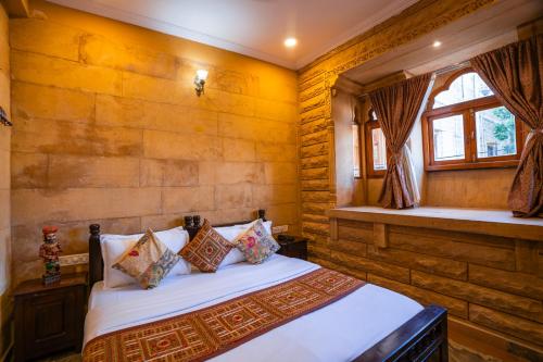 a bedroom with a bed and a window at Hotel Helsinki House in Jaisalmer