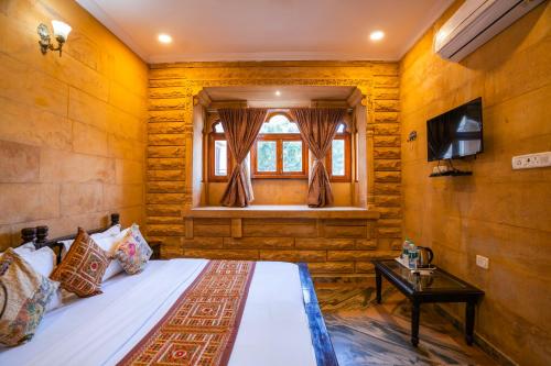 a bedroom with a bed and a window at Hotel Helsinki House in Jaisalmer