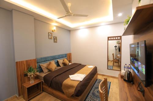 a bedroom with a bed and a flat screen tv at Hotel Mahadev Rishikesh in Rishīkesh