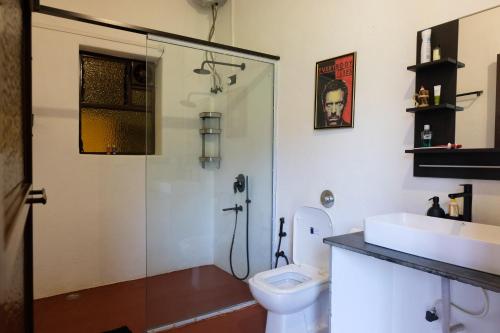ein Bad mit einer Dusche, einem WC und einem Waschbecken in der Unterkunft King's Landing for Pets in Karjat