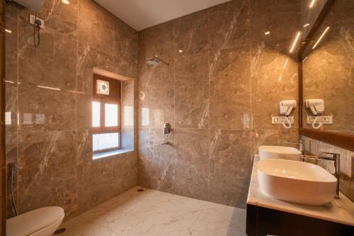 a bathroom with a sink and a toilet and a shower at Hotel Helsinki House in Jaisalmer
