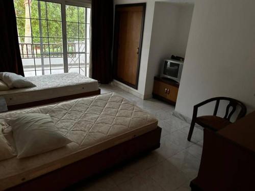 a bedroom with two beds and a tv and a window at One - bedroom building 174 in Sharm El Sheikh