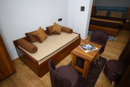a bedroom with a bed and a table and chairs at Hotel Mahadev Rishikesh in Rishīkesh